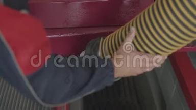 一个服务站工作人员在汽车的排气管上放一根管子来测量烟雾和废气。